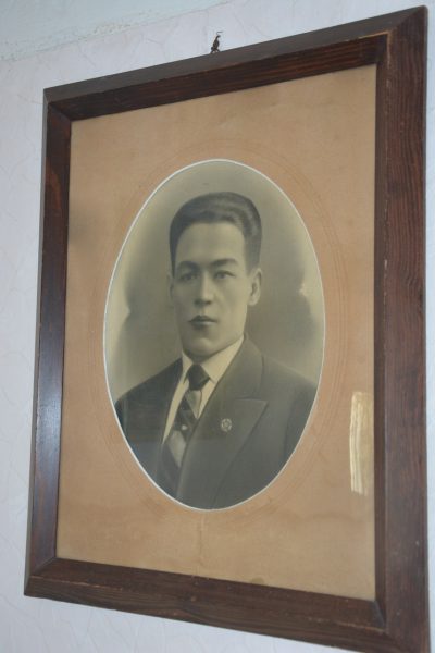 Framed vintage black-and-white portrait of a man in a suit and tie.
